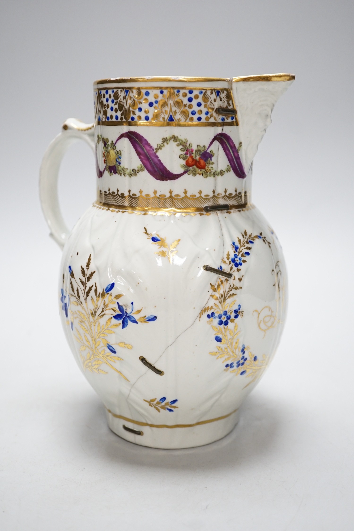 An 18th century Caughley very rare polychrome mask jug, elaboratley painted and gilded with two initials in a dry blue and gilt wreath, Gittins Col., Pictured Caughley Bicentenary Exhibition 1999, with labels, 19cms high